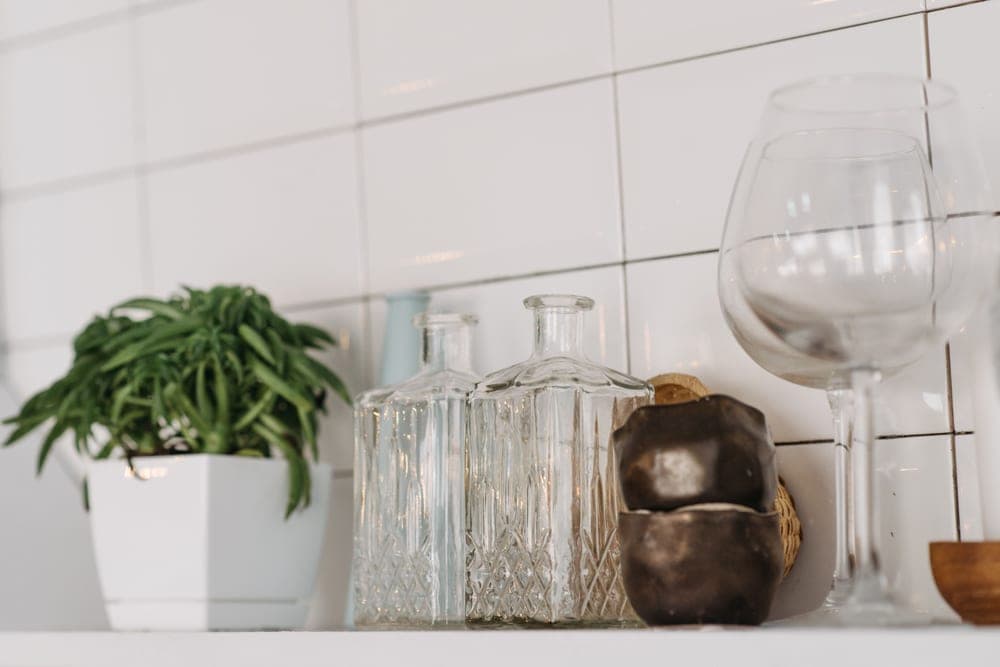 A clear glass bottle of water on a shelf