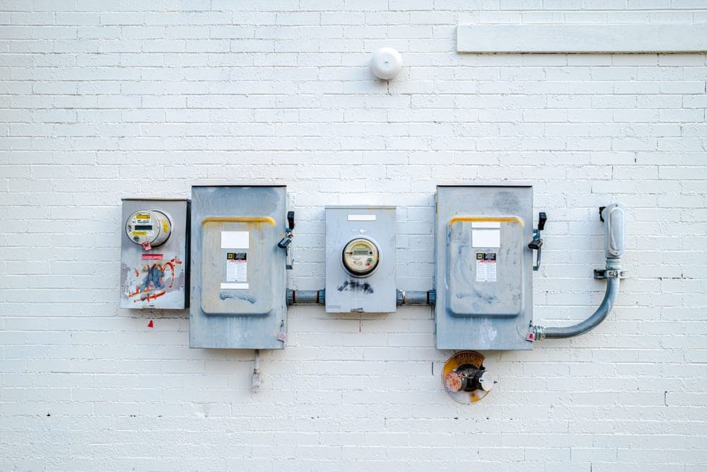 An electricity meter beside a wall socket