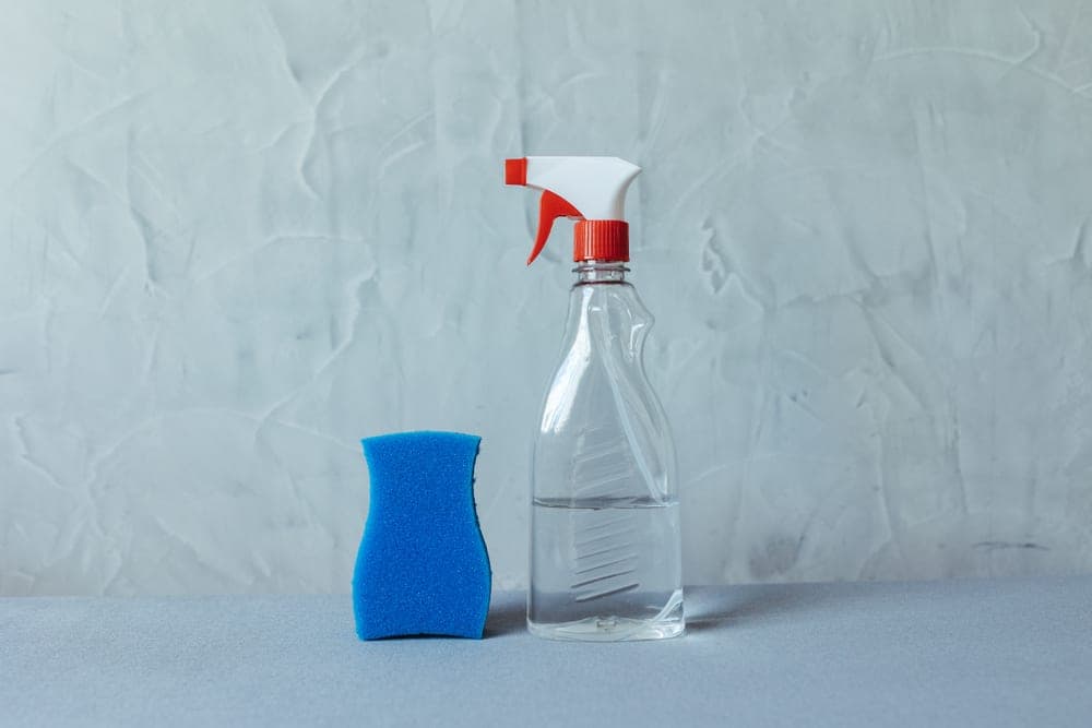 A spray bottle beside folded laundry