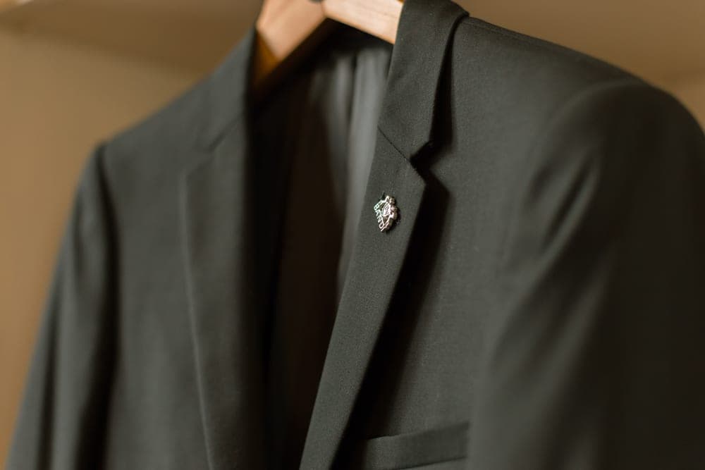 A tailored jacket hanging on a wooden hanger