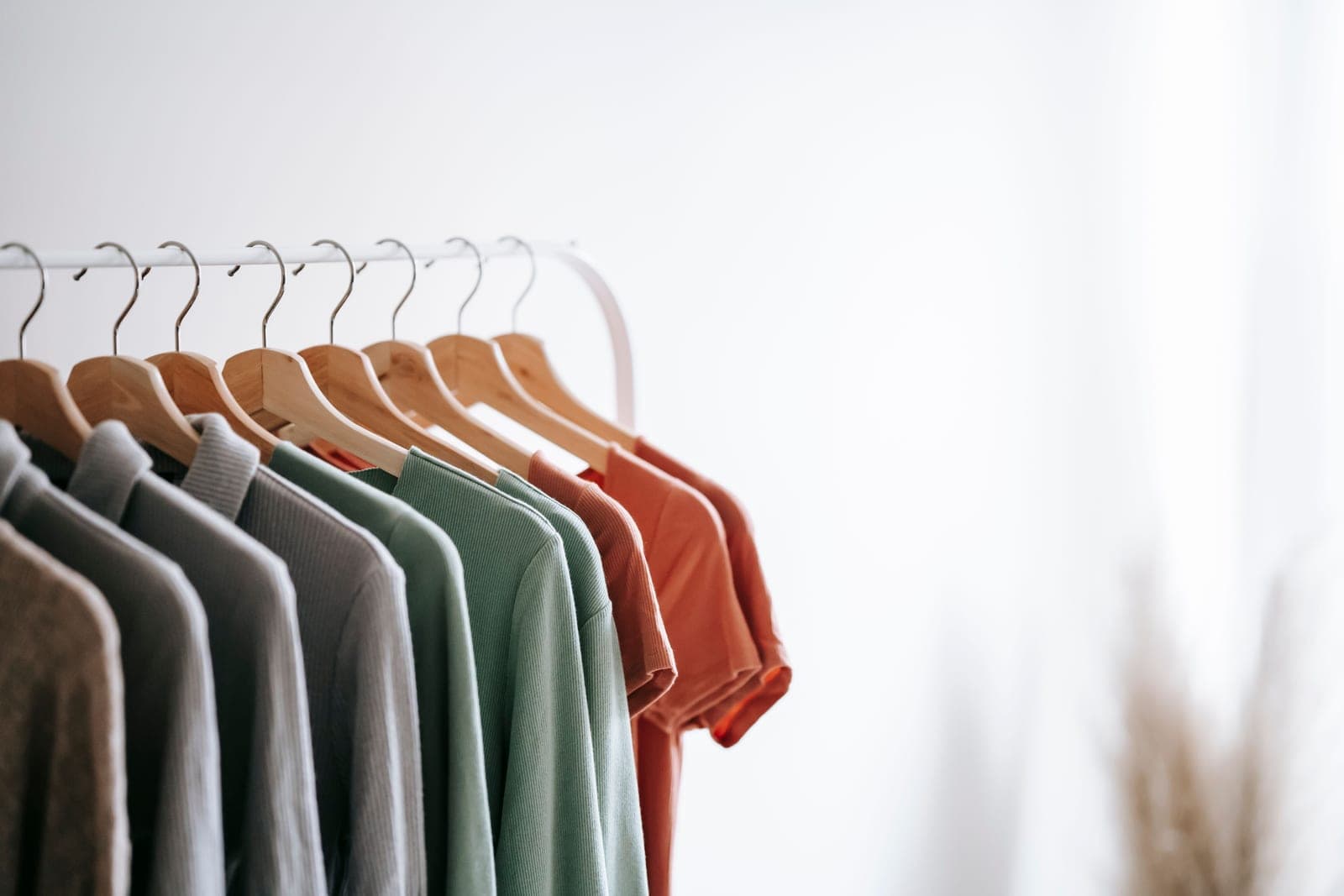 Shirts hanging on a rail in a bright wardrobe