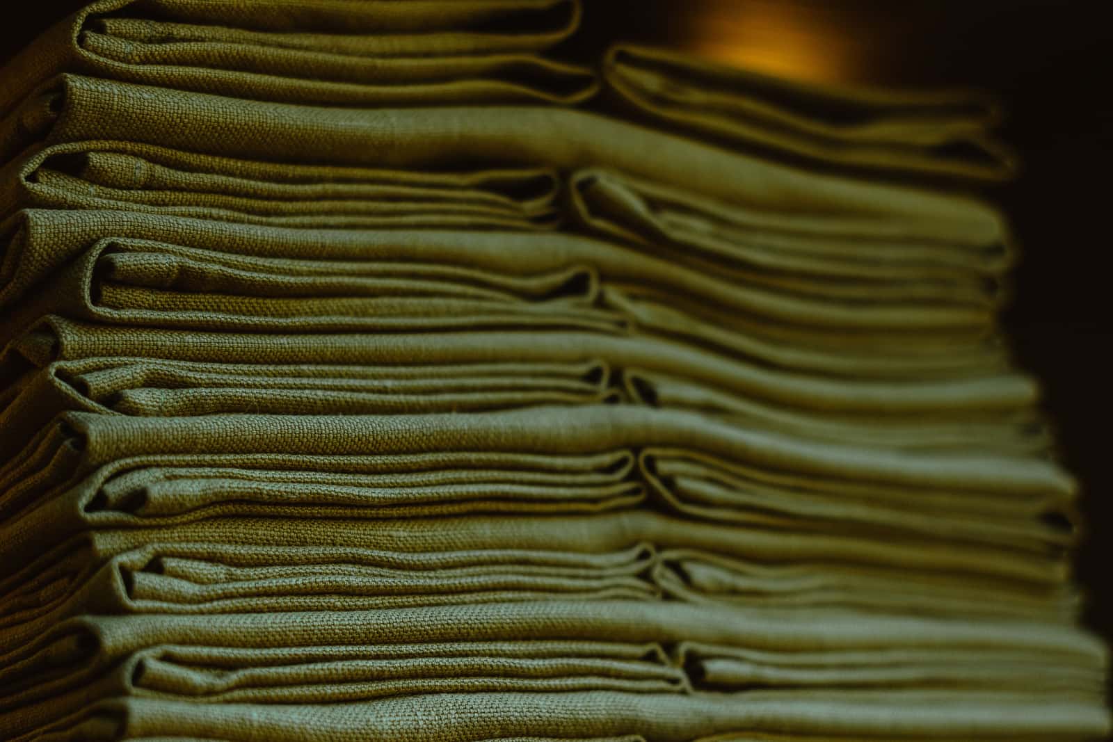 Folded shirts stacked on a plain wooden table