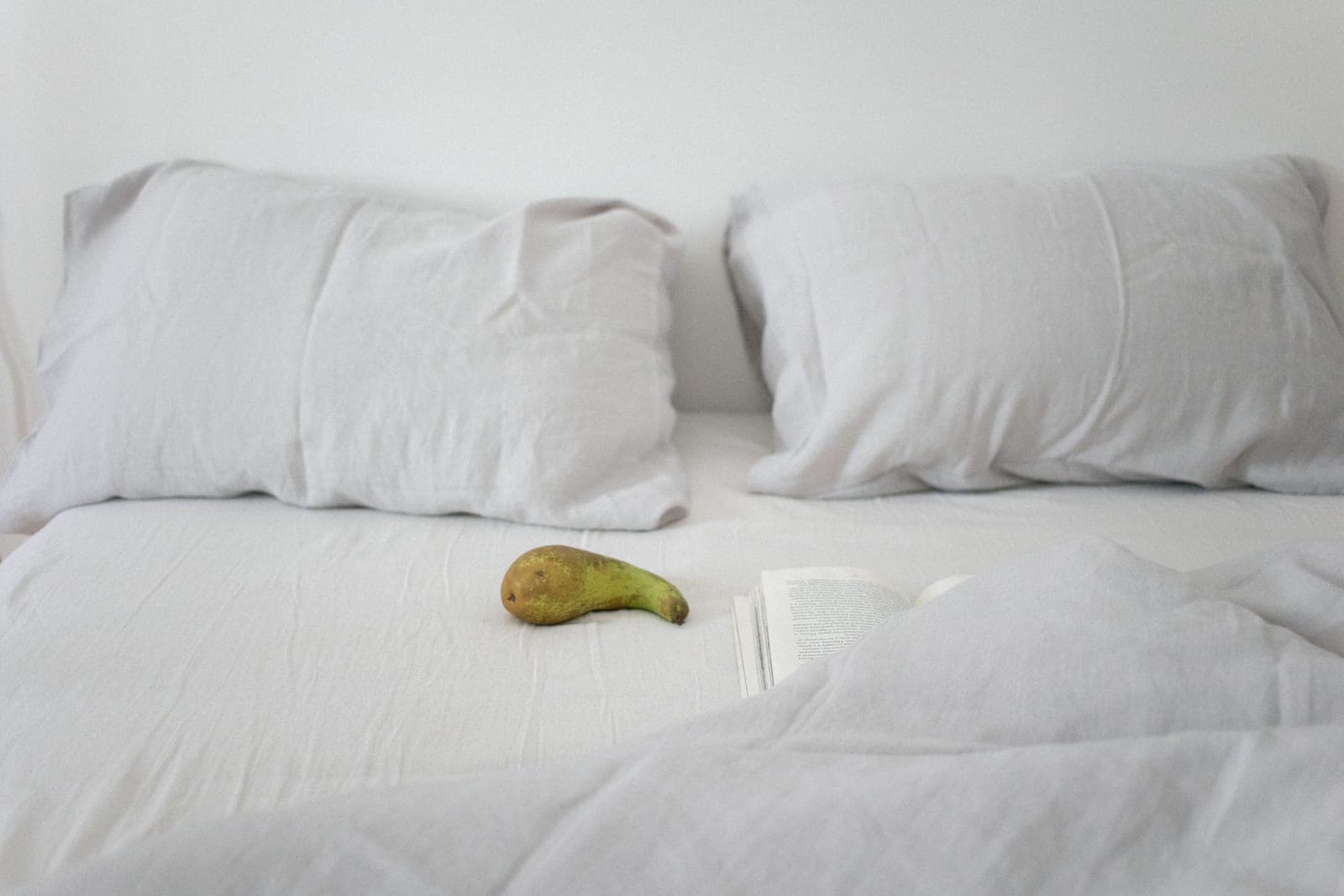 A neatly made bed with white linen bedding