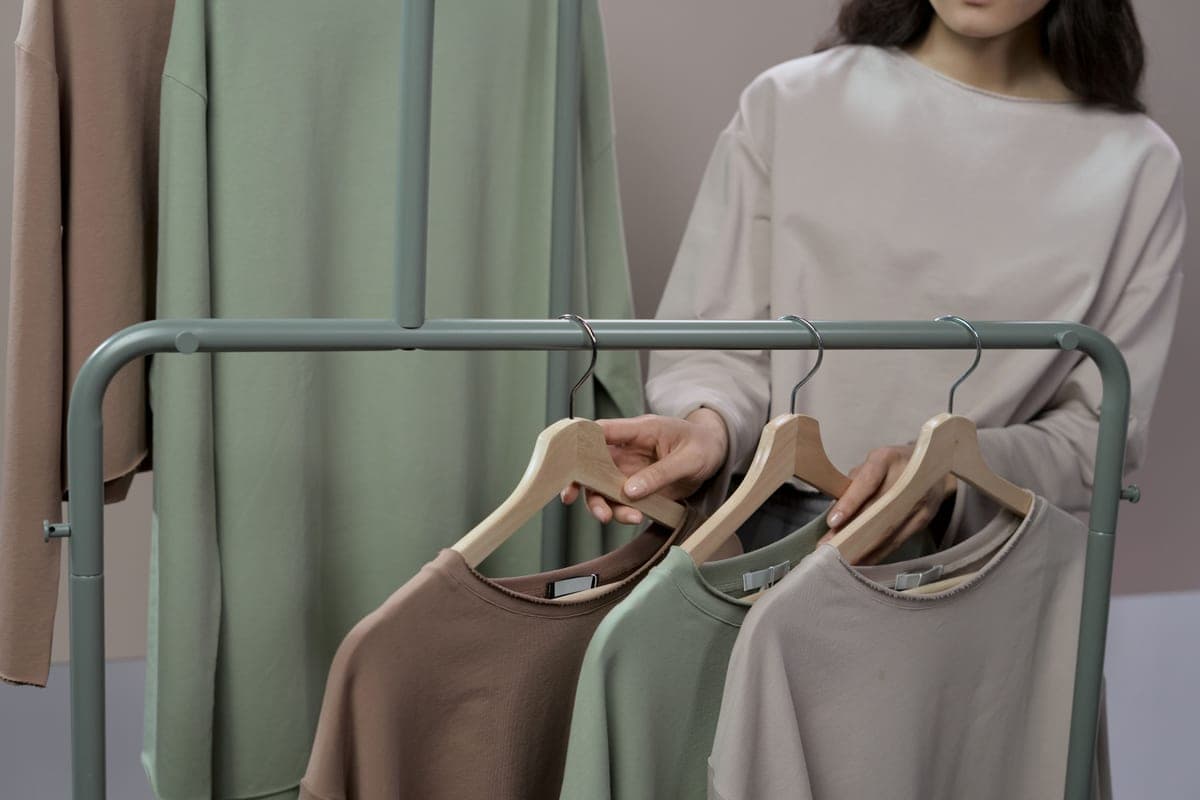 A delicate blouse hanging on a padded hanger in soft light