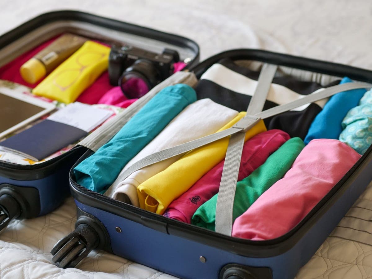 A small travel appliance beside a packed bag